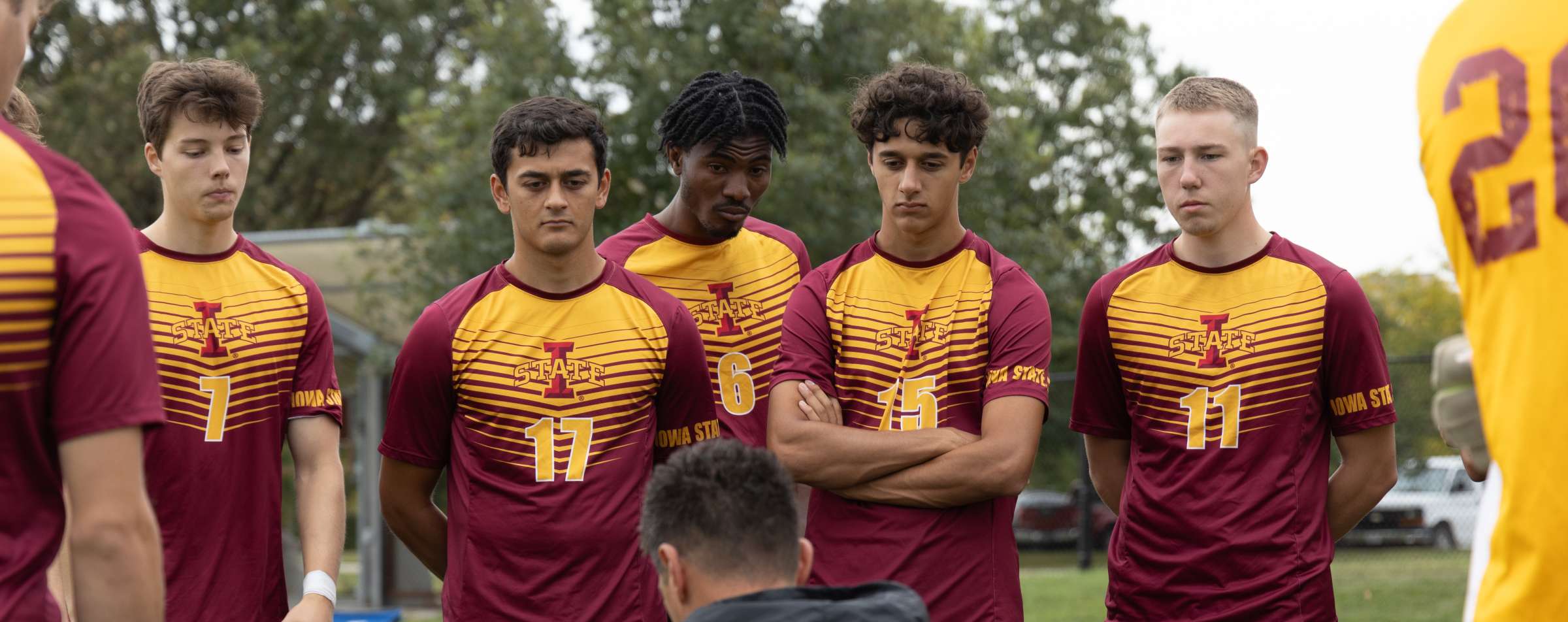 Members of the men's soccer sport club at Iowa State stand in a huddle.