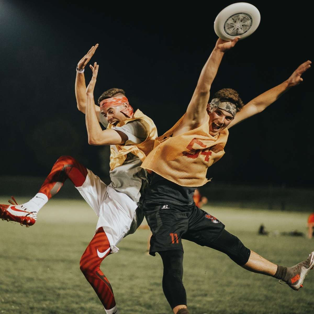 two students celebrate while playing ultimate frisbee